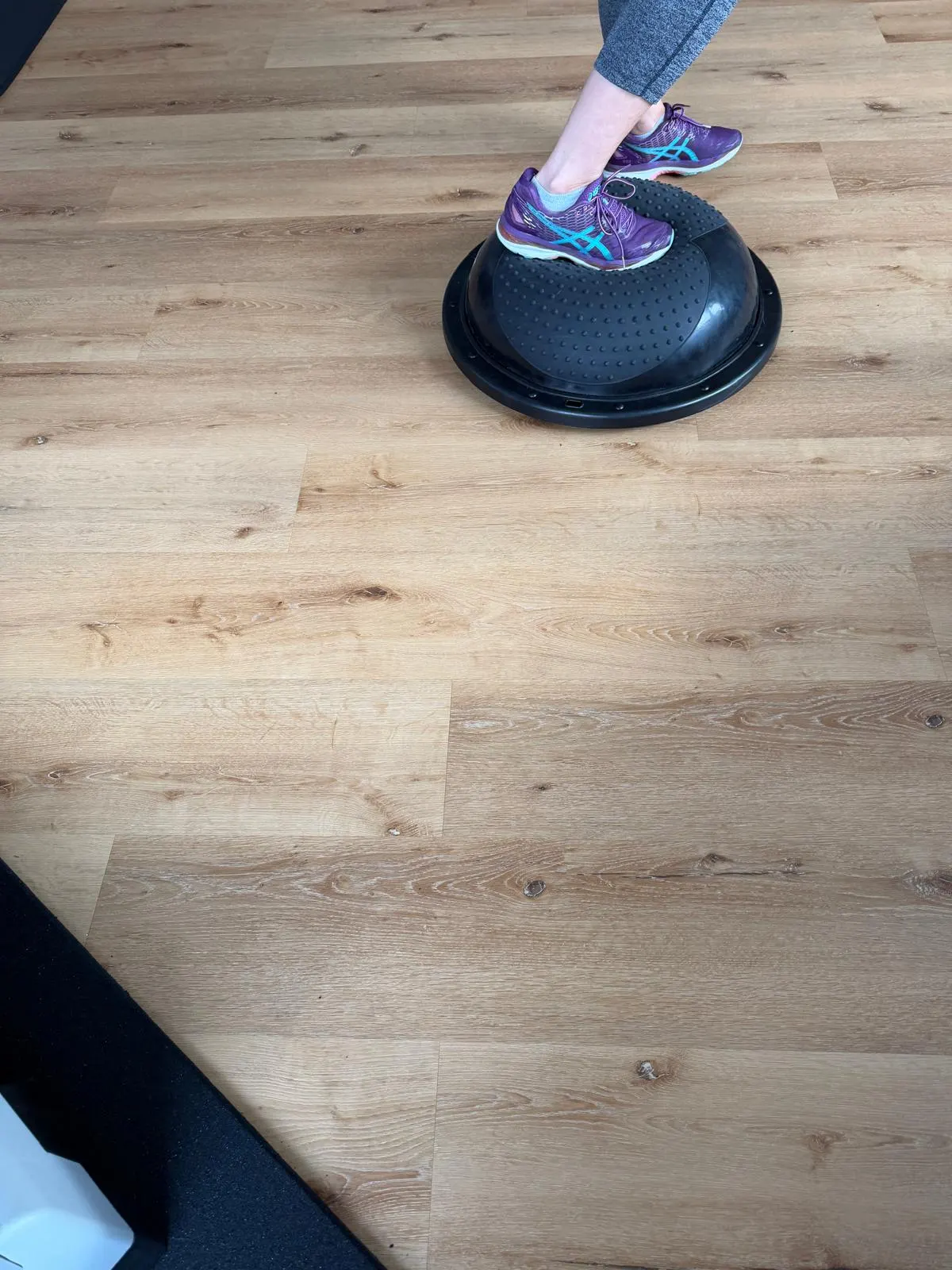 Exercice d’équilibre sur demi-ballon dans la salle de coaching